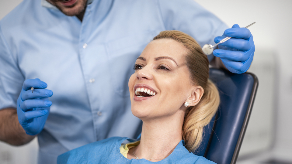 Angst vor dem Zahnarzt: Wie kann man sie überwinden? Eine glückliche Frau lässt sich ohne Angst behandeln