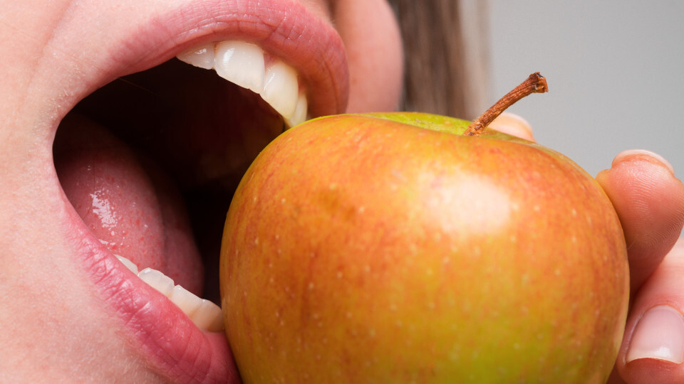 Eine Frau beißt in eine Apfel