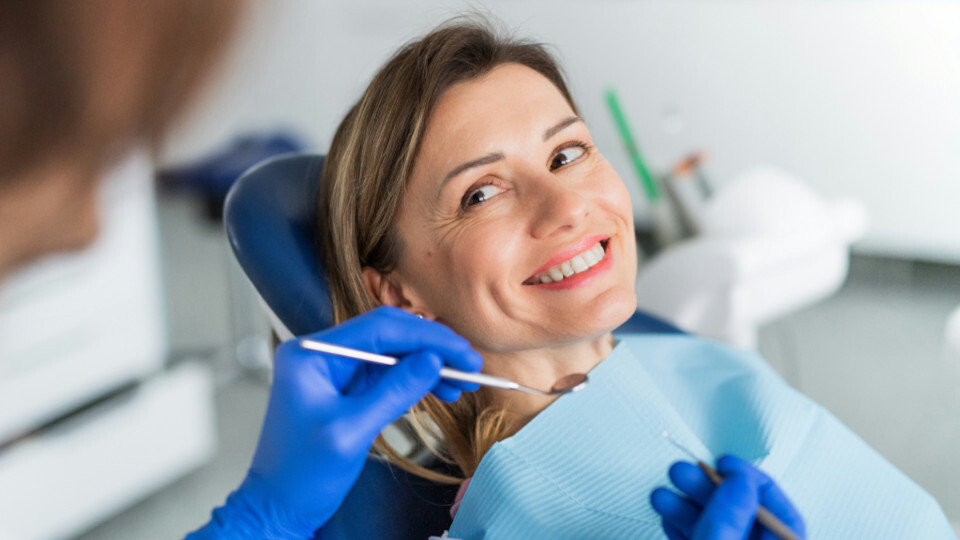 Eine lächelnde Frau im Zahnarztstuhl